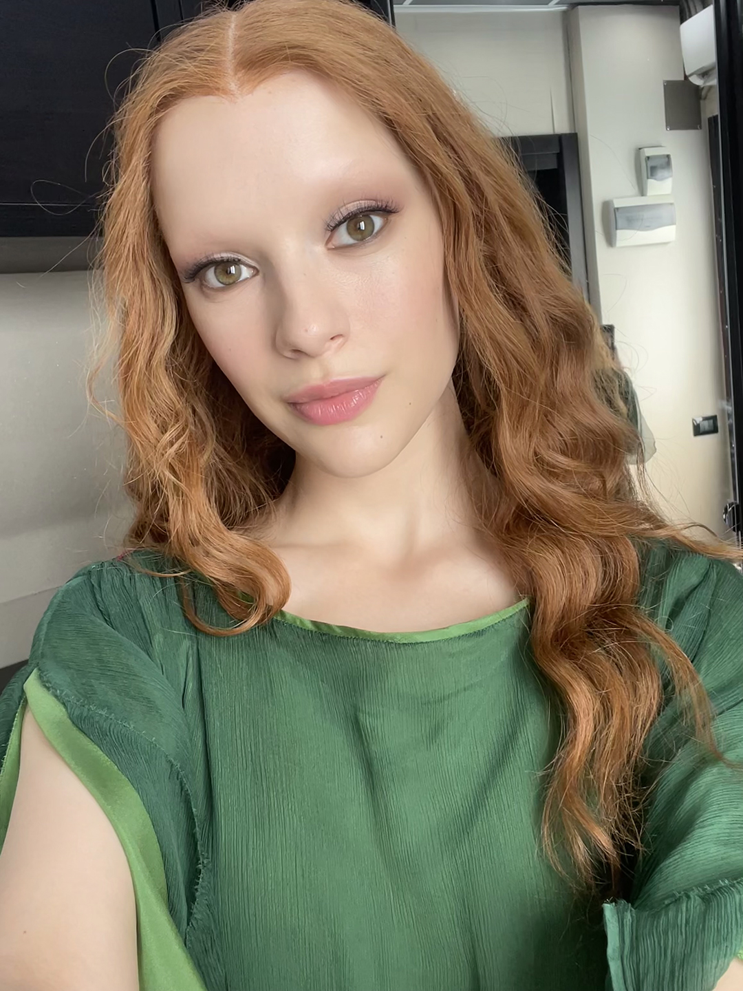 A behind the scenes selfie picture of actress and singer Joelle dressed as her character Vipsania from Domina season 2 in a ginger wig and dark green dress.